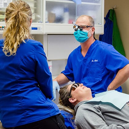 Our two specialists in the dental office with a patient who is lying in the dentist's chair